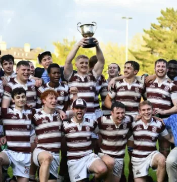 The New College rugby team lifts the trophy