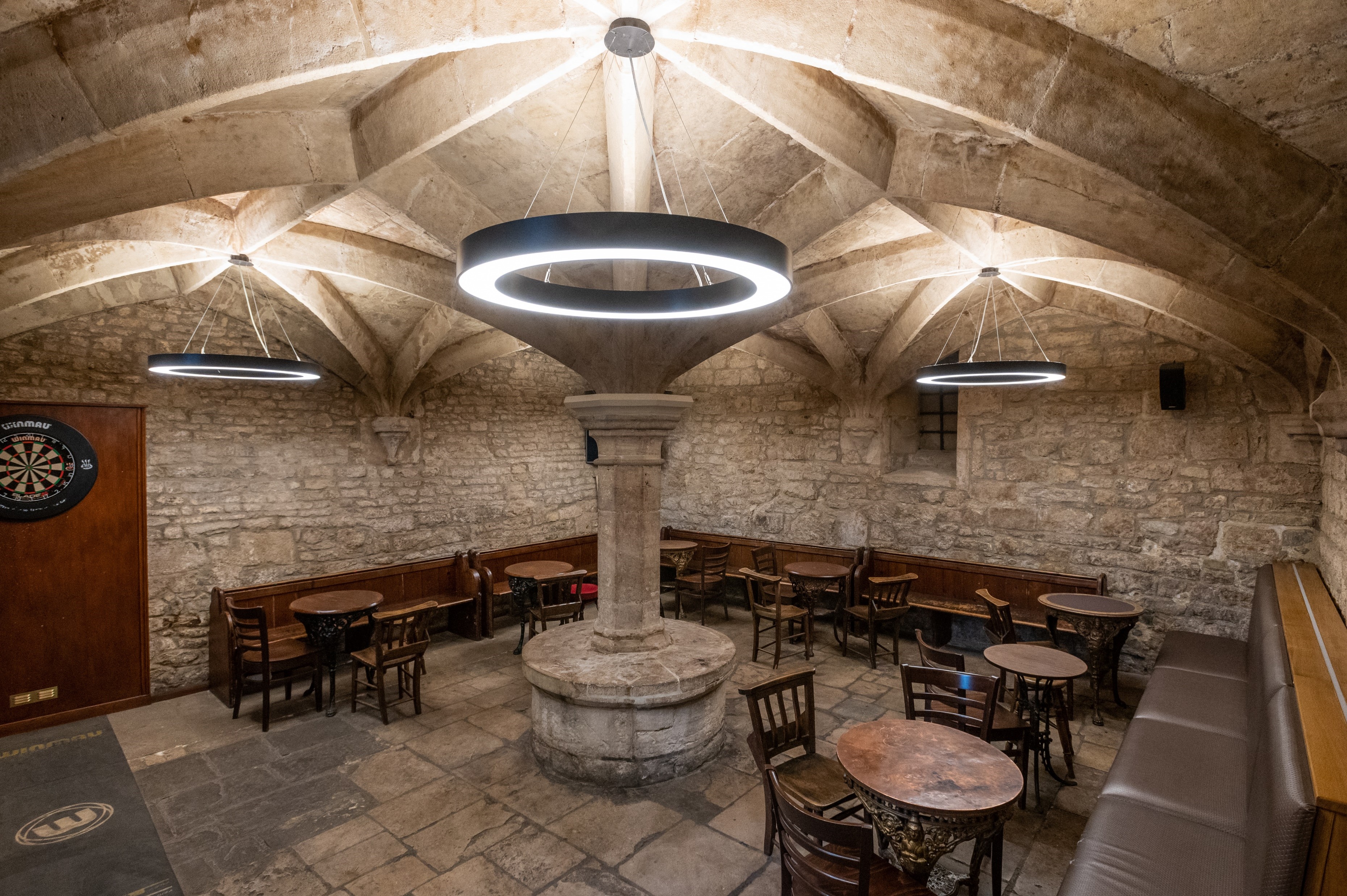 Bar seating in old beer cellar with dart board
