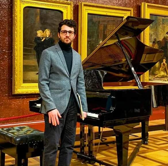 Richard Moukarzel stands in front of a piano