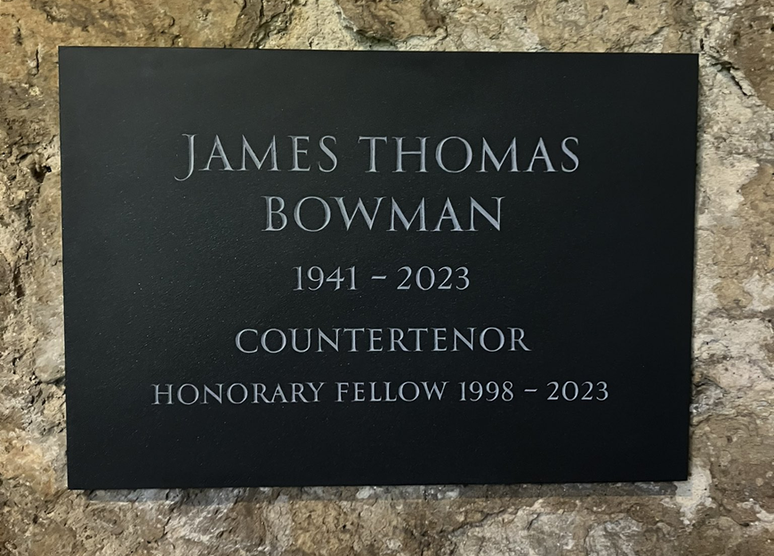 The plaque to James Bowman in the cloisters. It reads: James Thomas Bowman, 1941-2023. Countertenor. Honorary Fellow, 1998-2023.