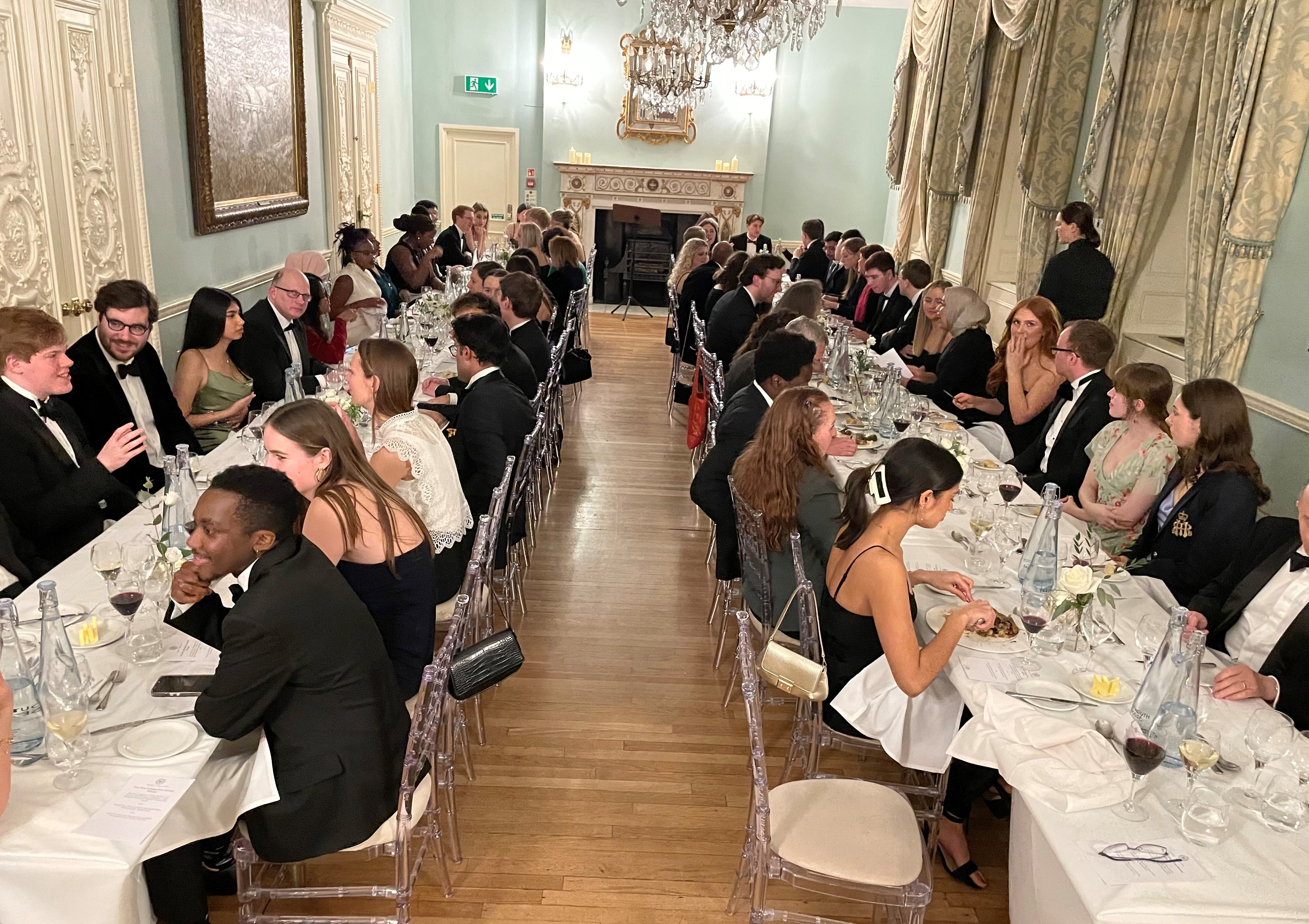 The dining room: two tables filled with guests enjoying a meal at Dartmouth House, Mayfair