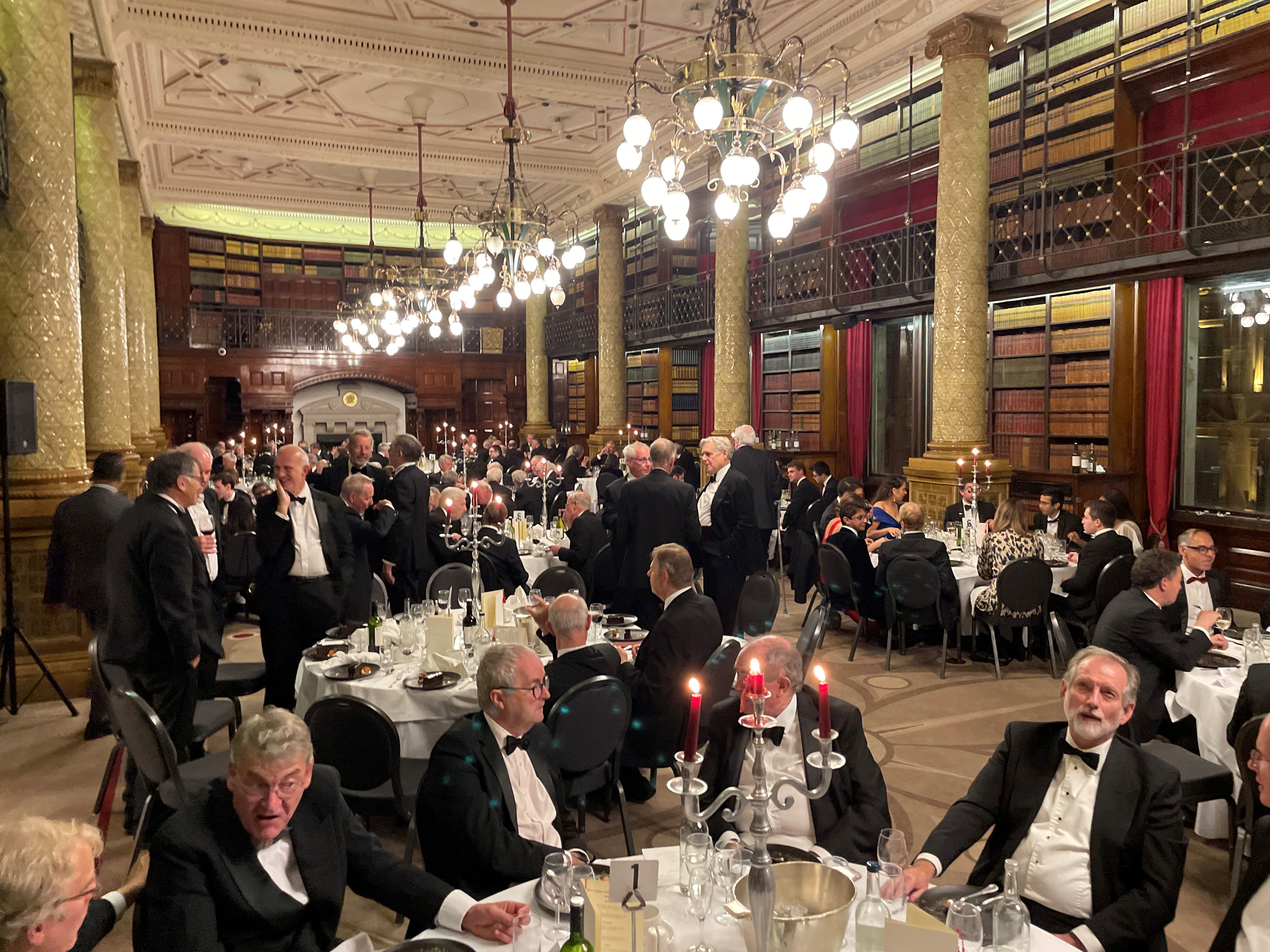 New College Old Members gathered around tables in a spectacular hall with chandeliers