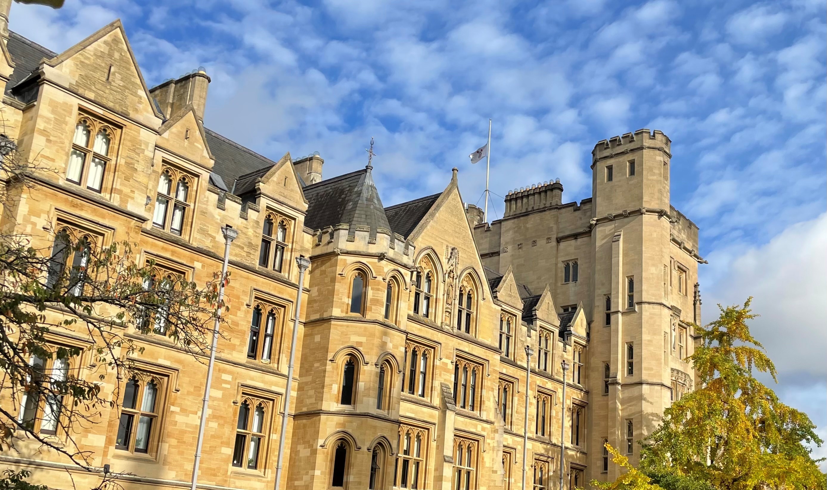 The College flag flying at half mast over the Robinson Tower