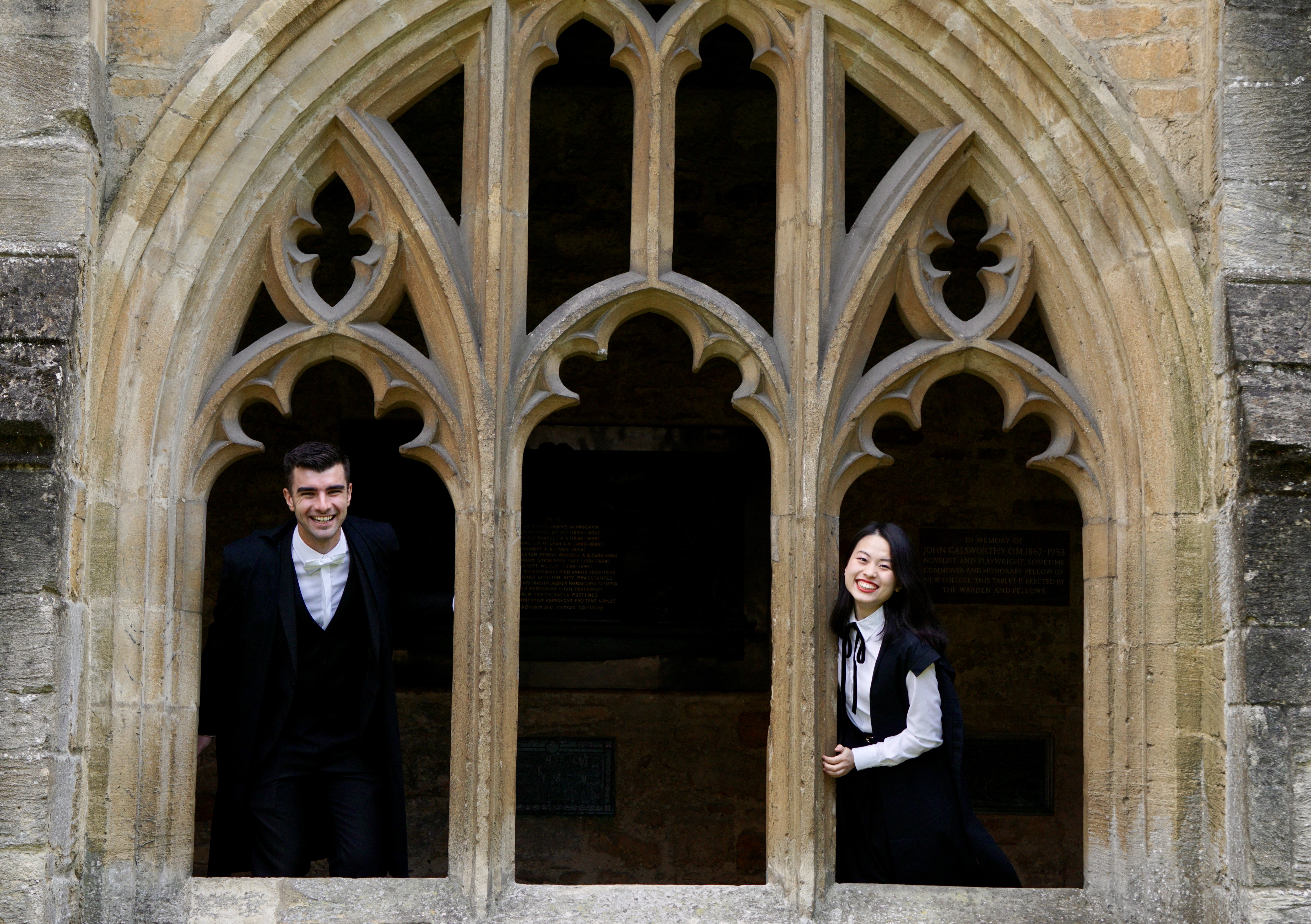 Two students in sub fusc, socially distanced in the Cloisters