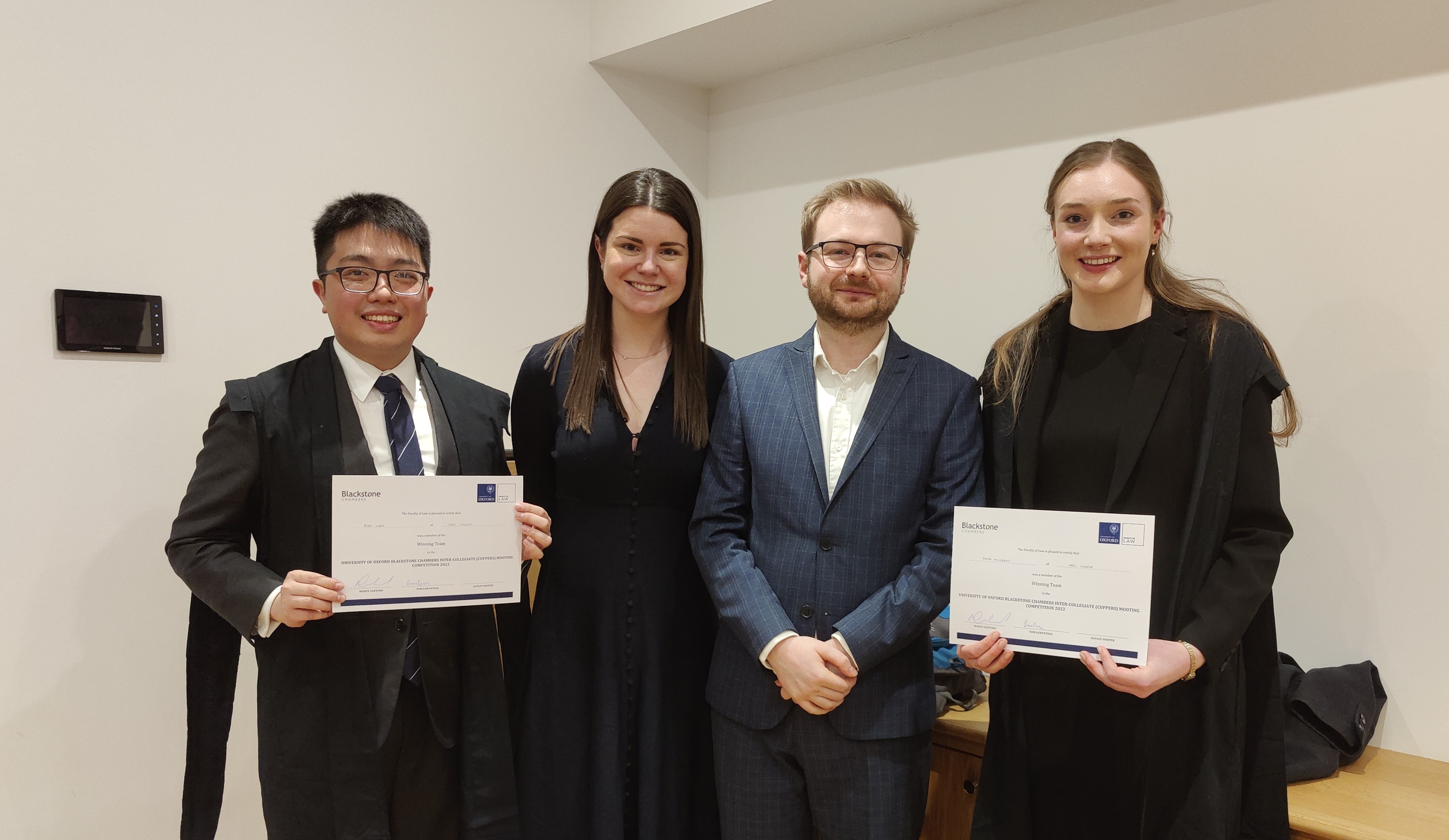 Alex and Dana stand with their winners certificates, alongside the judges