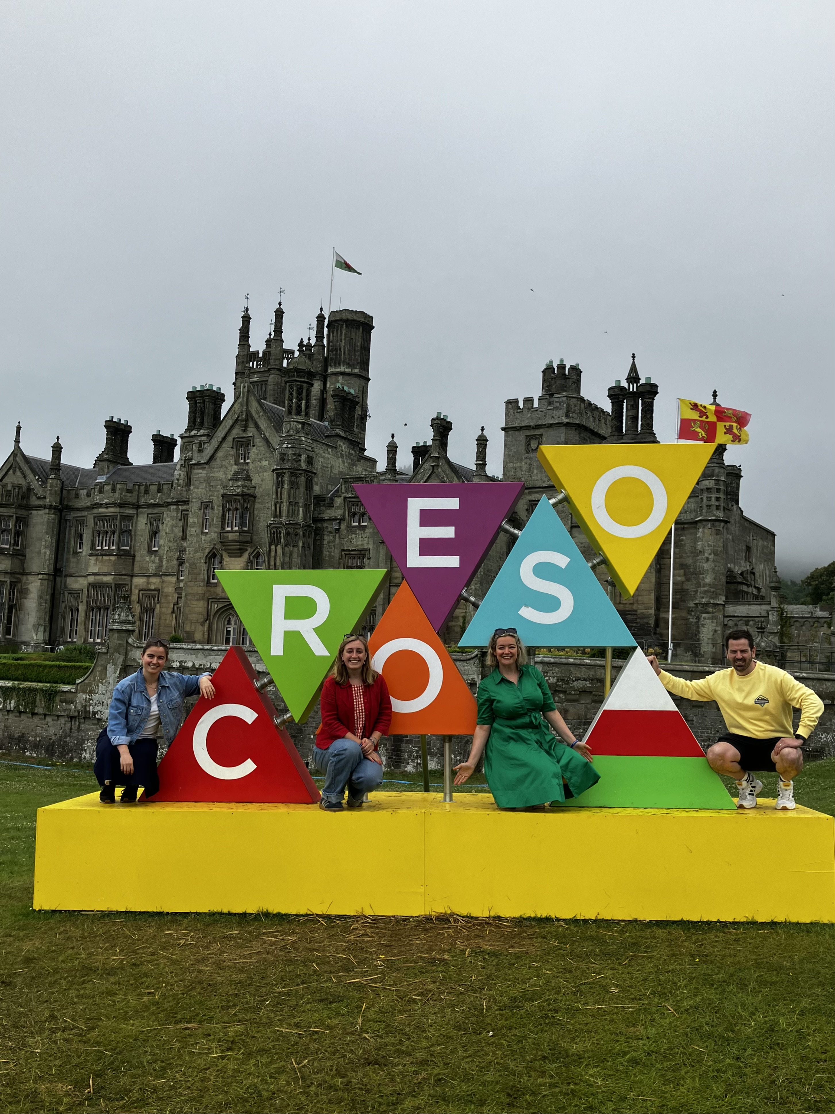 The team in front of a sign reading 'welcome' in welsh