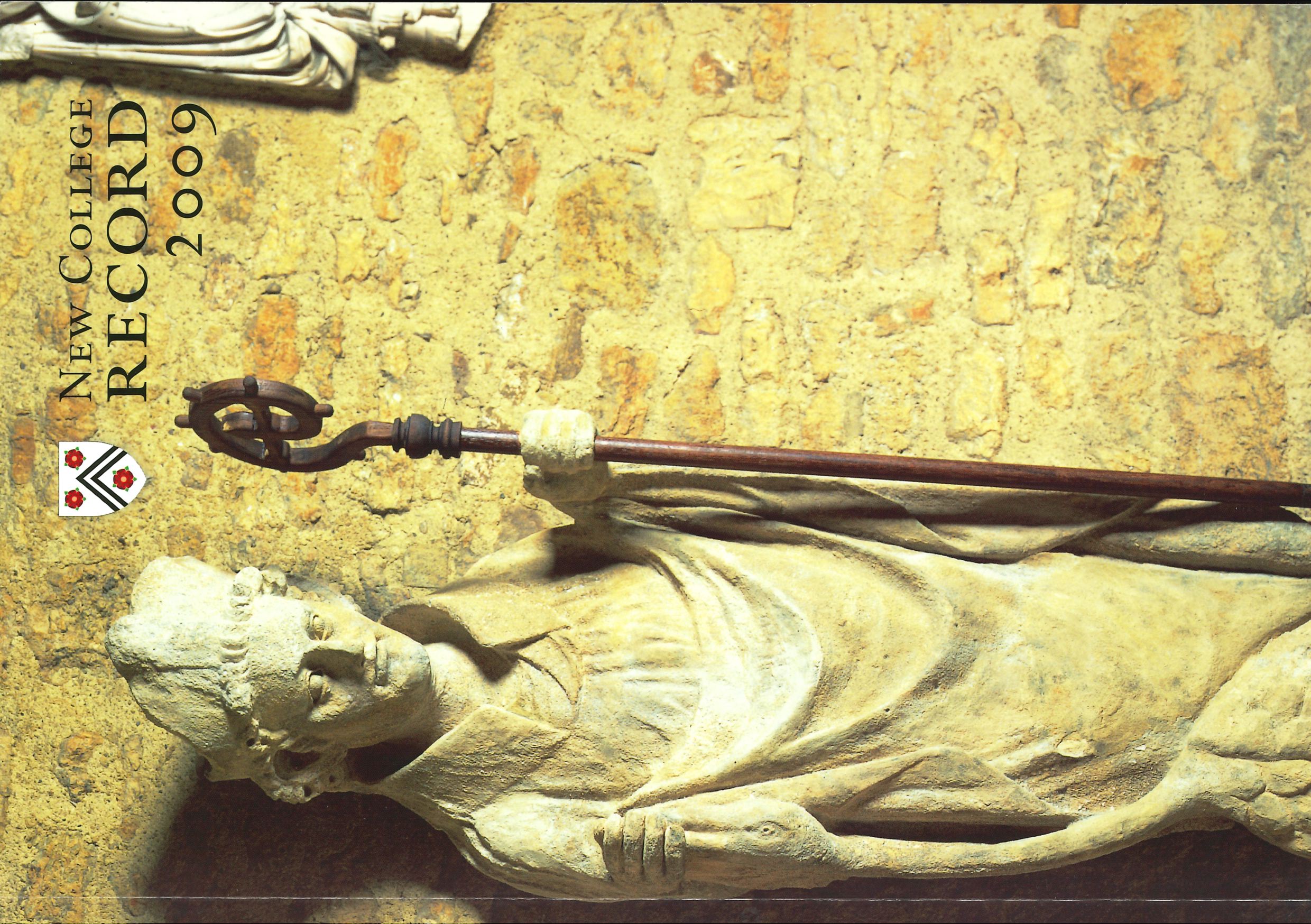 Statue with hooked wooden staff, with New College shield and 'New College Record 2009' written in the top right corner