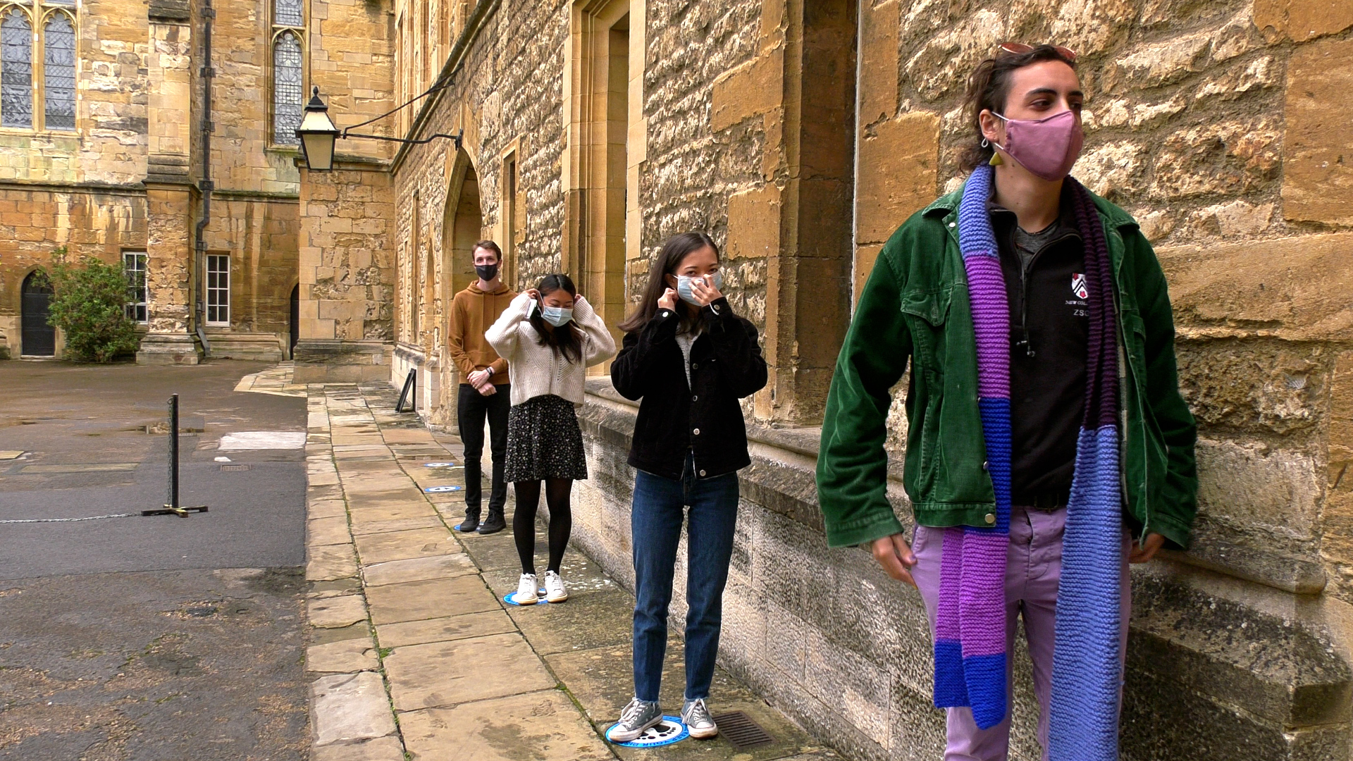 Socially distanced students in masks outside a tutorial room