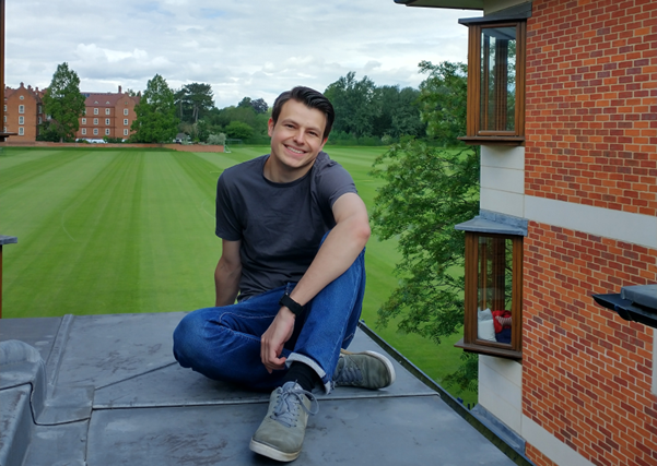 Aidan sits on top of the MCR Pavilion with the sports fields in the background