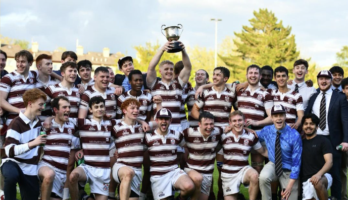 The New College rugby team lifts the trophy