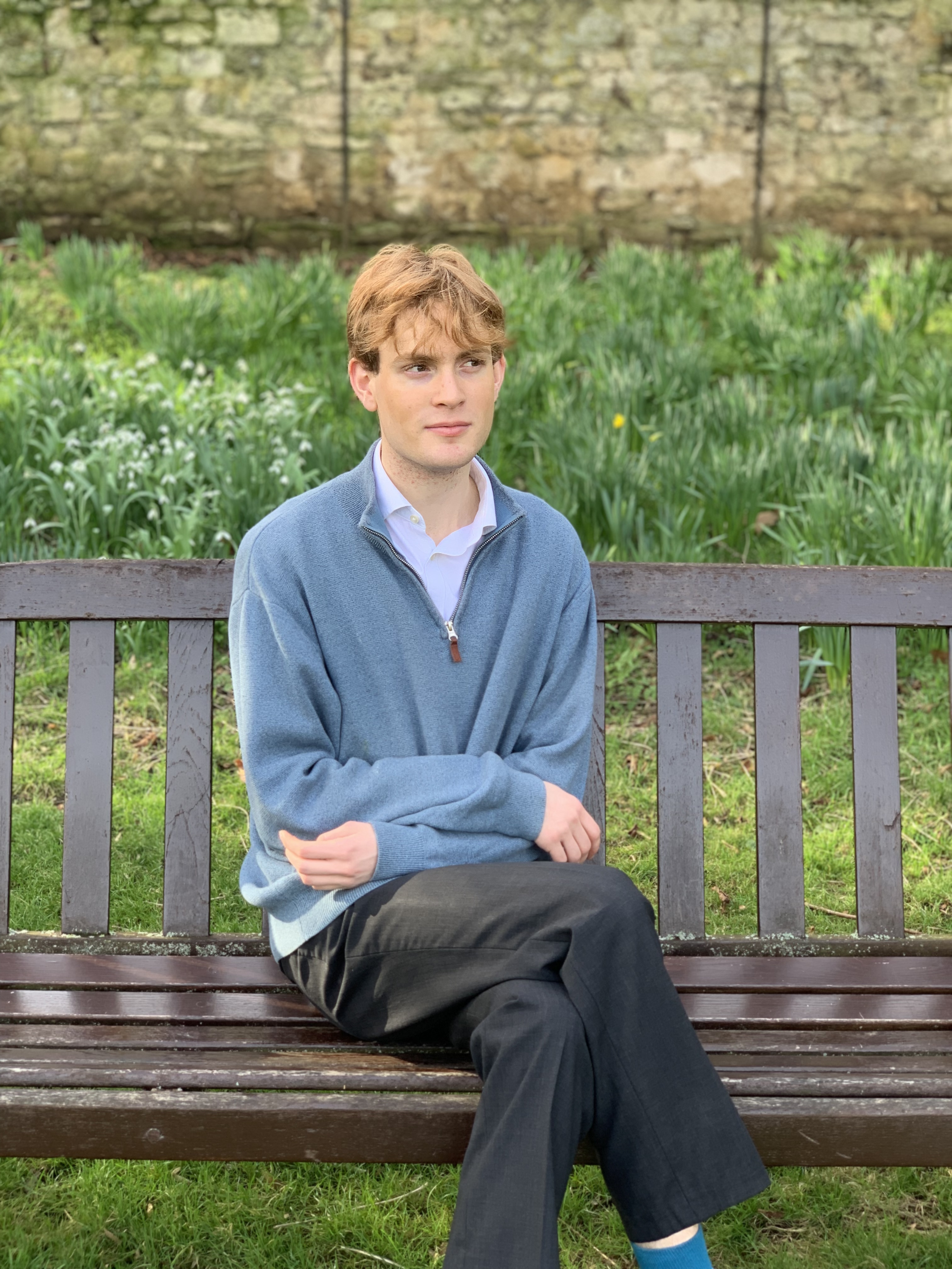 Patrick sitting on a bench in New College gardens