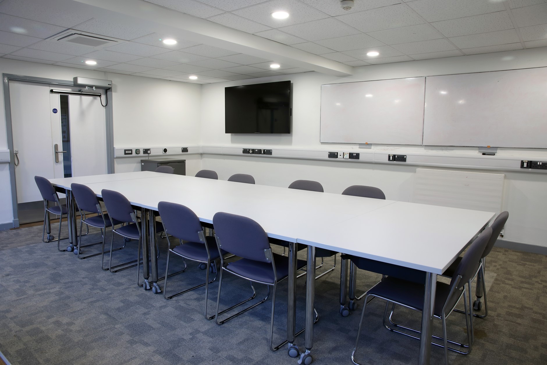 Spooner Room 2 - a boardroom meeting room with white boards and TV screen