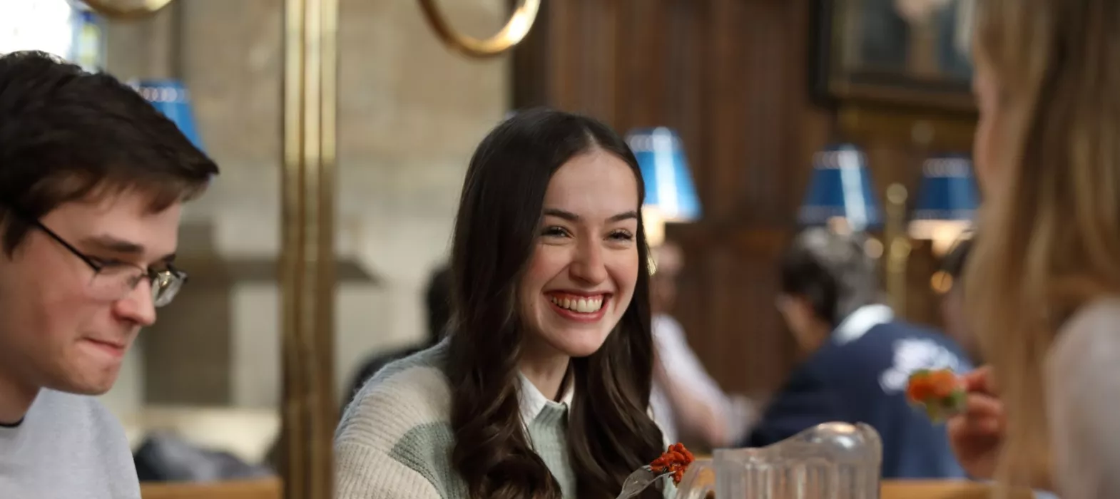 A smiling student eating in Hall