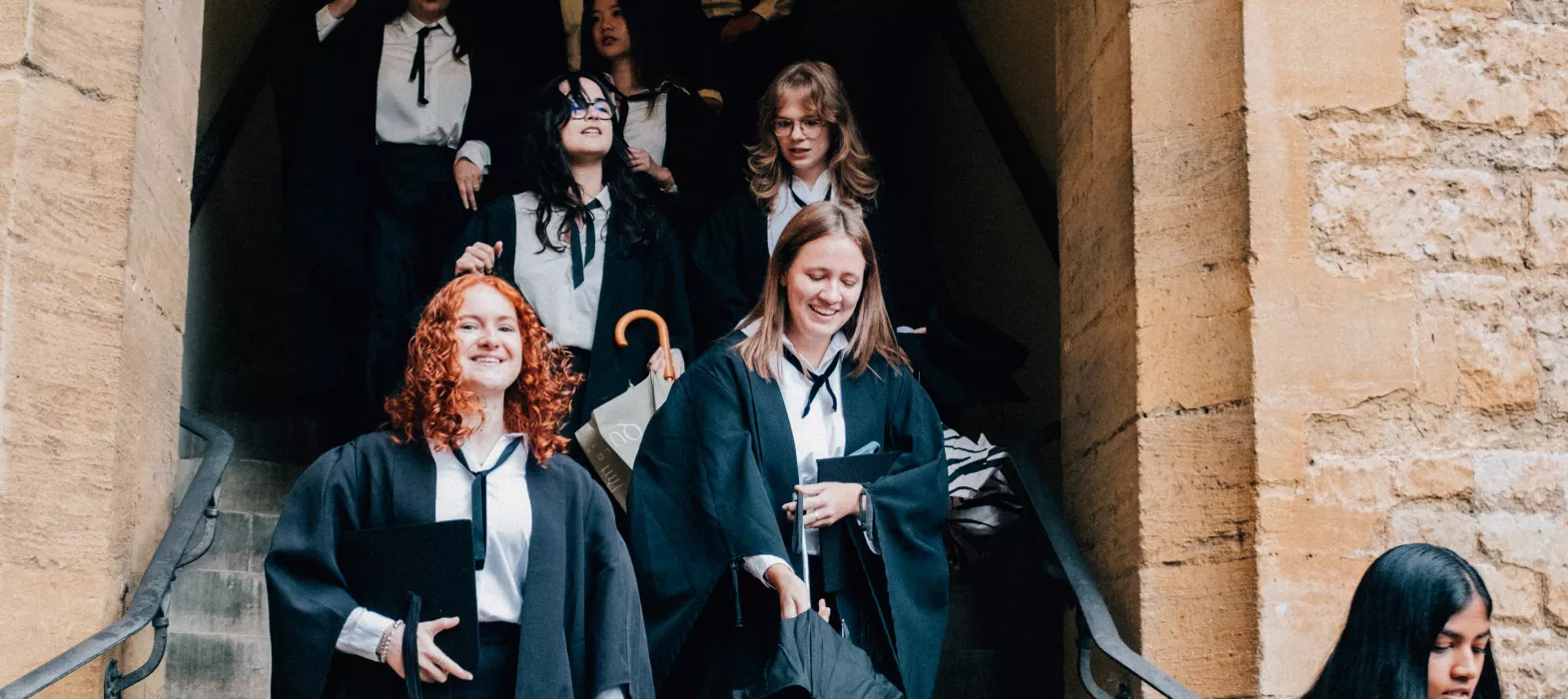 Students in sub-fusc walking down our dining hall stairs