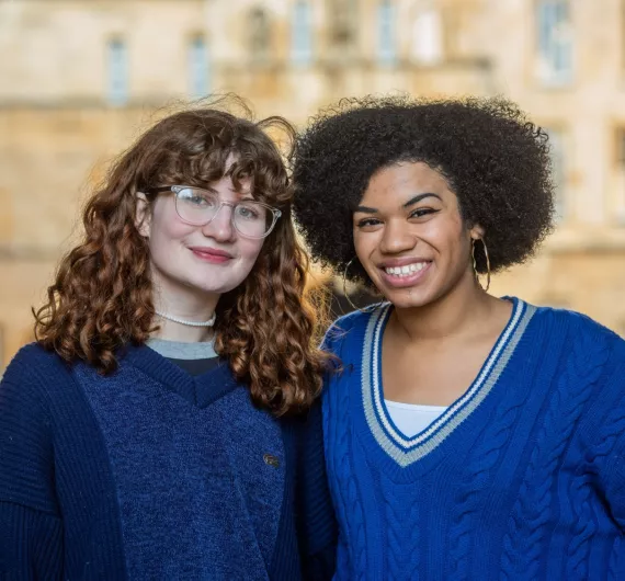 Two students smiling in front of Great Quad