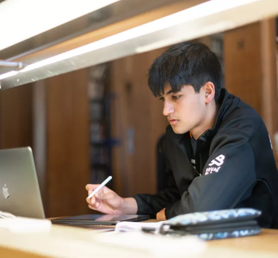 Student working at a laptop in the Library