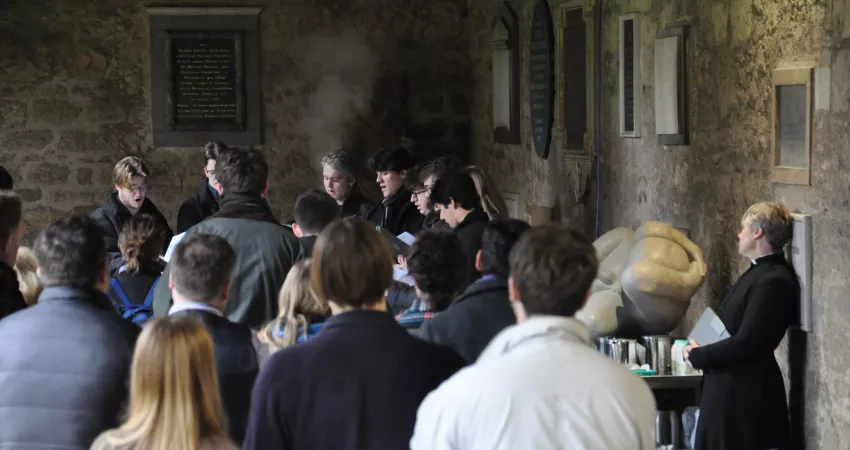 The New Men performing in the Cloisters, with a large audience watching and listening