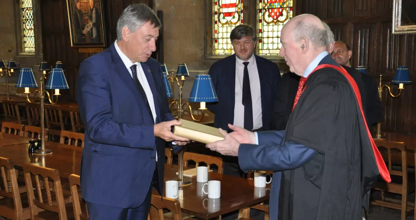 The Minister-President giving the Warden a book as a gift in the Dining Hall