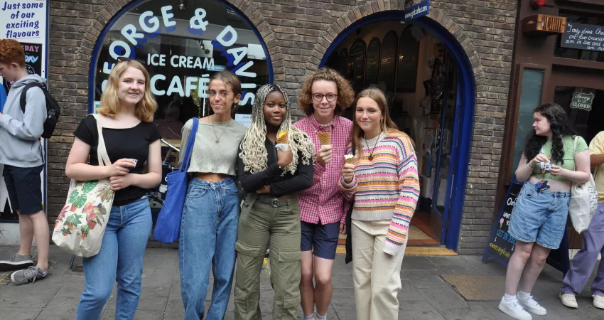 Five students with ice creams, smiling at the camera