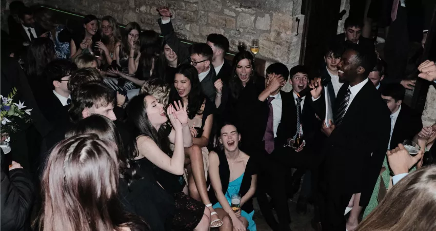 A student gives a speech while lots of others laugh