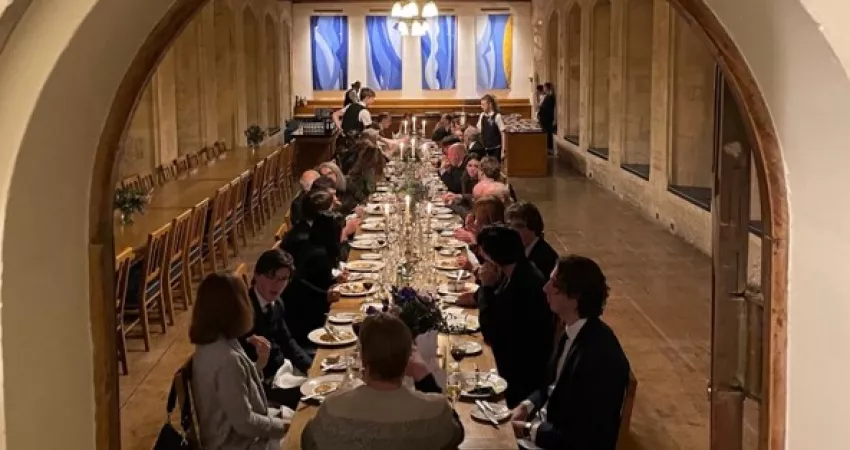 People having dinner at long table