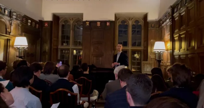 Man singing with piano accompaniment, to an audience