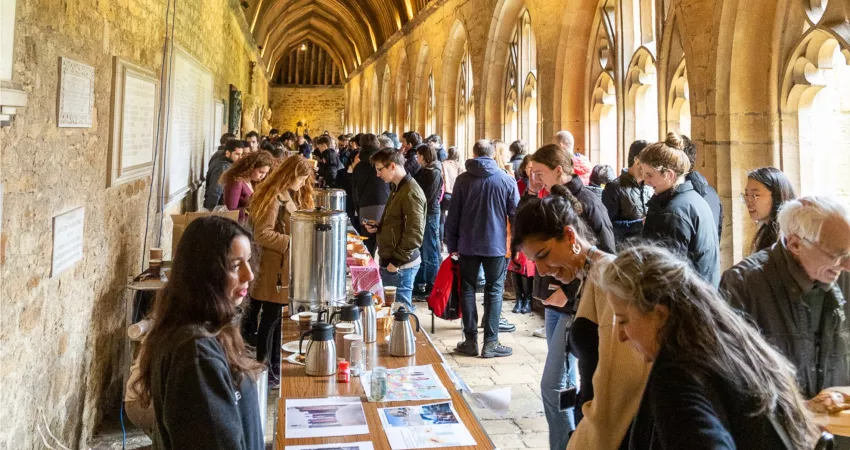 Lots of people gathered in Cloisters talking, looking at photos and getting coffee
