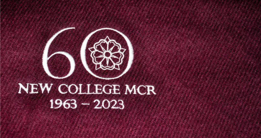 Sewn '60 New College MCR 1963-2023' in white on a burgundy background
