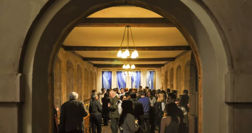 A long room full of people, framed by a door frame