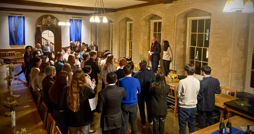 Warden and MCR President give a speech to people in a large room