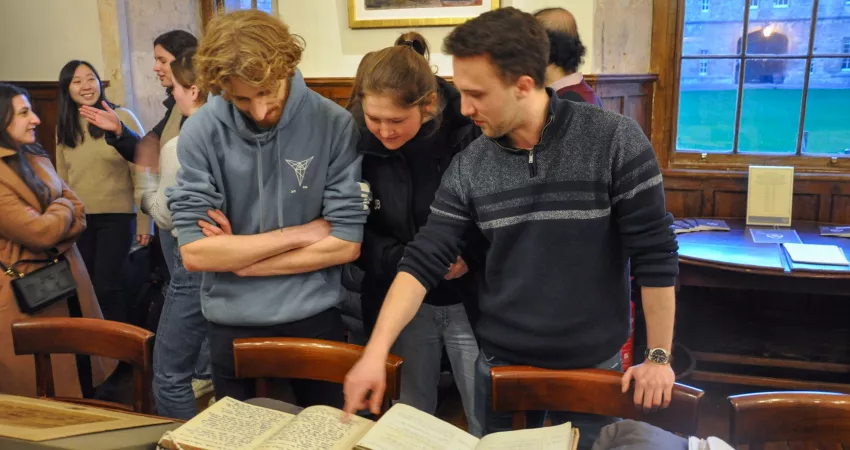 Three students look at an old book
