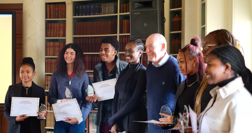 The Warden surrounded by students holding certificates