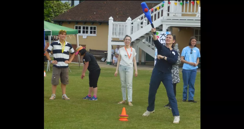 Vice-Chancellor playing rounders with people watching on