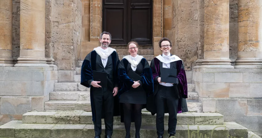 The Proctors and Assessor stand outside the Sheldonian Theatre