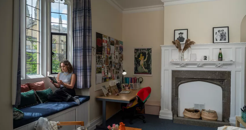 A student reads in her room in New Buildings