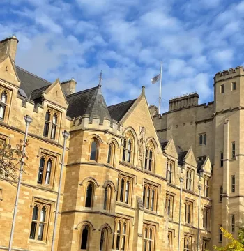 New College flag flying at half mast over the Robinson Tower