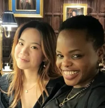 Two students smiling in a medieval dining hall