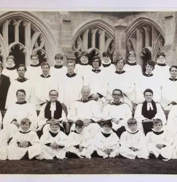 A choir composed of men and boys posed in rows in Cloisters