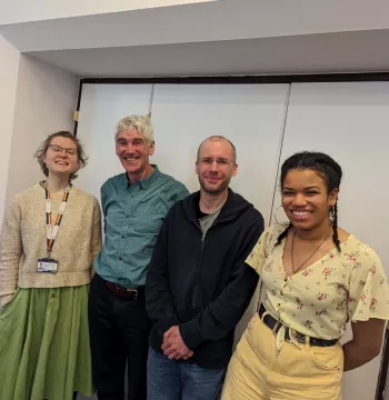 Two students and two teachers smiling at the camera