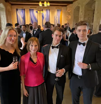 Four people in formal dress smiling at the camera