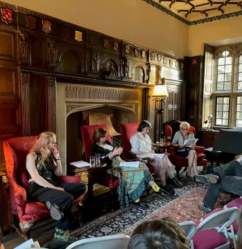 A group of people sitting in chairs in an old, wood-panelled room