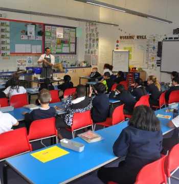 A chef demonstrates to students in a classroom