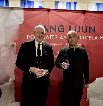 Fang Lijun and Miles Young standing in front of the exhibition banner