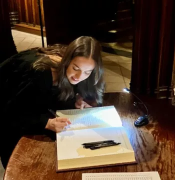 A student signs their name in the scholars and exhibitioners register