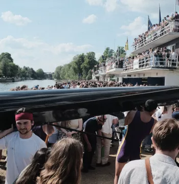 New College rowers carry their boat to the river