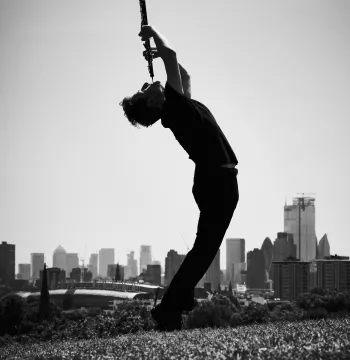 Black and white photo of oboist playing his instrument in a park overlooking London