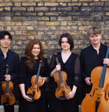Image showing the four musicians of the Neruda Quartet holding their instruments in front of a brick wall