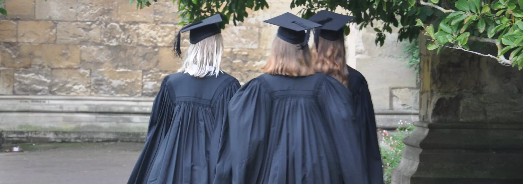 Students in mortarboards and gowns in the Front Quad